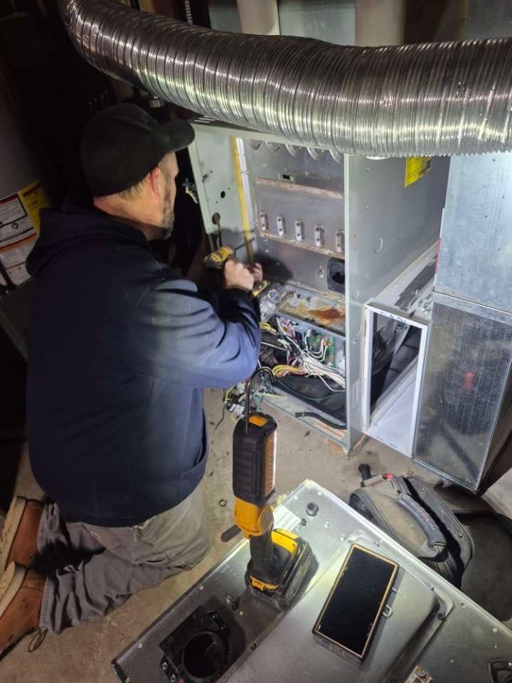 Tri-State Heating and Cooling technician repairing a gas furnace