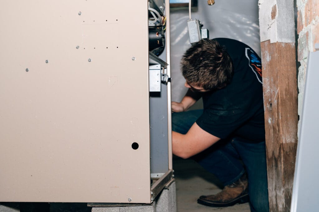 Technician replacing a furnace filter during a tune-up